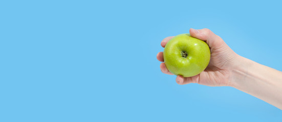 Hand holding organic delicious apple Isolated on blue Background. Healthy eating and dieting concept