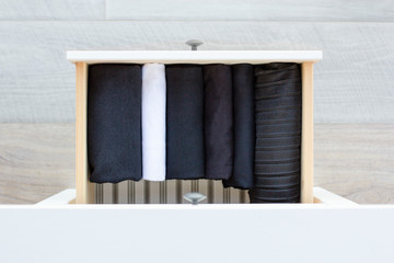 neatly folded black and white laconic clothes in a drawer