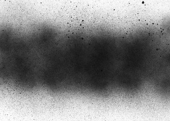 Subtle grit texture of black spray track on white paper. Particles and blots of paint