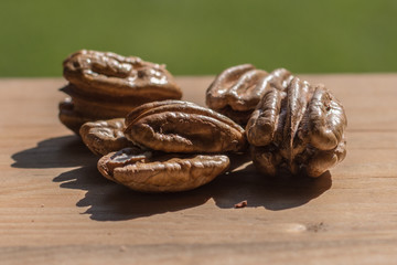 Shelled pecan nuts outdoors on wood surface