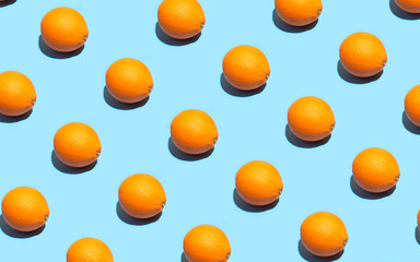 Fruit pattern of fresh orange on blue background. Top view. Summer concept. Collage. Healthy eating and dieting concept.