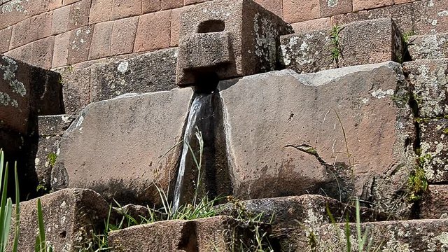 Water fountain emanating between the stones of the Sacred Valley of the Incas in Pisaq - Cusco