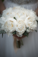 The bride holds a wedding bouquet in pastel colors