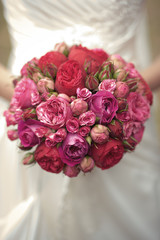 The bride holds a wedding bouquet in purple tones