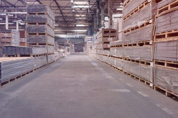 Production line of the wooden floor factory. Warehouse of boards in the production. Pile of cut wood in factory storage warehouse.Lumber in warehouse.