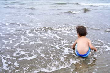 波打ち際で遊ぶ子供