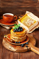 Pancakes with blueberry on ceramic plate  and tea cup