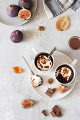 Chocolate mug cupcake with cream cheese or ricotta with caramel sauce in a white ceramic mug on a light grey stone background. Healthy breakfast or dessert. Comfort autumn or winter food. 