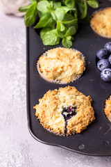 Blueberry muffins with fresh berries and mint leaves in black baking dish. Copy space.