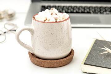 Autumn workspace still life. Notebook and daily planner mock-up scene with, glasses and hot warming drink pumpkin latte ore coffe  with marshmallows. White table background. 