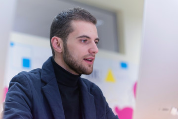 Young male Businessman working on modern computer. Businessman using innovative technologies. Businessman working on computer, software developing with modern tech on virtual screen.