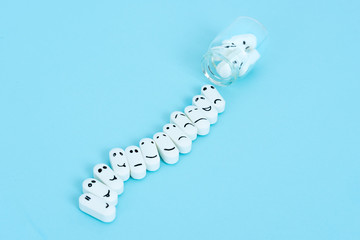  Pills with funny faces and a glass bottle on a blue background. Pharmacy antibiotic. Treating with antidepressant. Mental disorder. The concept of antidepressants and healing. Copy space.