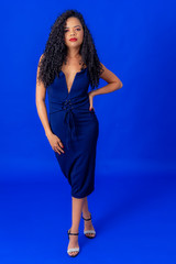 Curly hair girl wearing blue dress studio shot