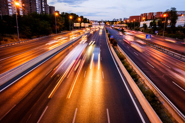 Fototapeta premium Car lights running at full speed through a network of roads within the city, long exposure to capture the movement.