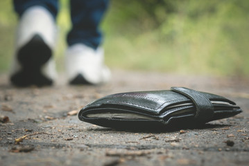 Lost wallet on road and is walking away woman.