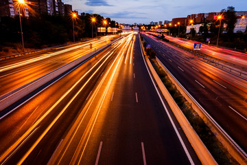 Intense traffic on the M-30 roads of Madrid one night, light trails and unfocused background.