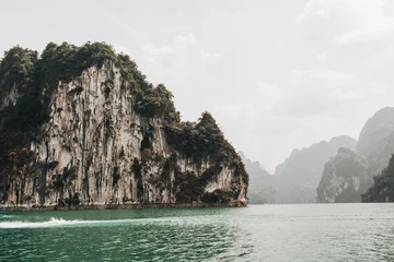 Foto auf Acrylglas Khaki Exotische und tropische dunkelgrüne Inseln mit Felsen und grünem See am Cheow Lan Lake, Khao Phang, Bezirk Ban Ta Khun, Thailand. Reiseurlaub und Abenteuerkonzept.