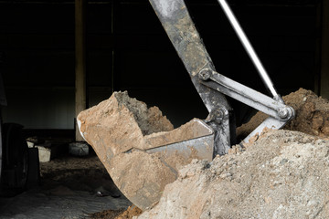 Bucket excavator digs soil at construction site