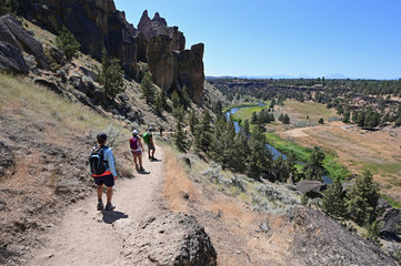 Hikers on Misery Ridge Trail in Smith Rock State Park near Terrebonne, Oregon on a cloudless summer day.