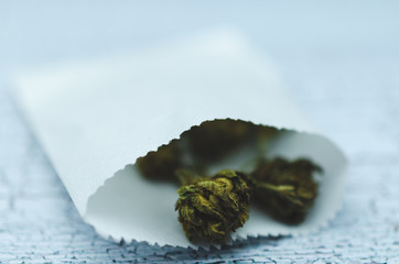 Marijuana cones in a white paper pharmacy bag