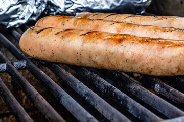 Mild Italian sauasge and baked potatoes on the grill. Calgary, Alberta, Canada