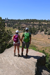Young couple enjoying view from Misery Ridge Trail in Smith Rock State Park, Oregon on clear cloudless summer day.