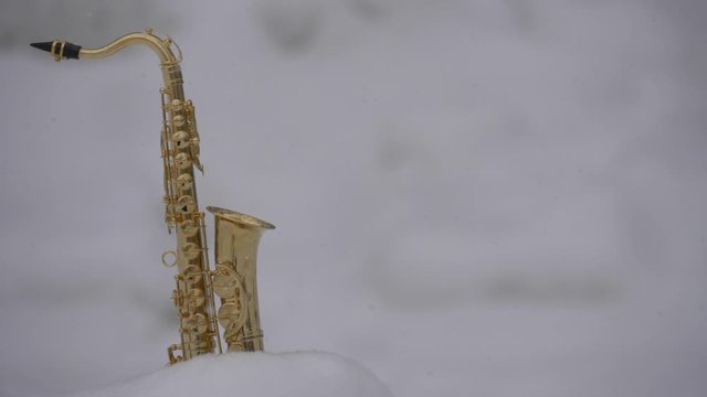 Winter saxophone on snow background
