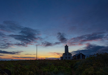 Fototapeta na wymiar Grotta Island Lighthouse, located off the Atlantic Ocean coast near the city of Reykjavik, Iceland, at sunset.