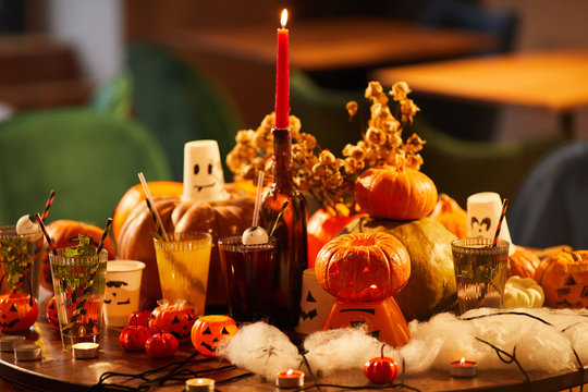Background image of Halloween decorations, pumpkins and candles set on table for party, copy space