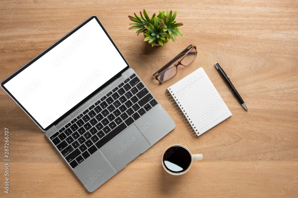 Poster Laptop computer with blank mock up screen is on top wooden office desk table with cup of black coffee and supplies.top view and copy space for text or design.