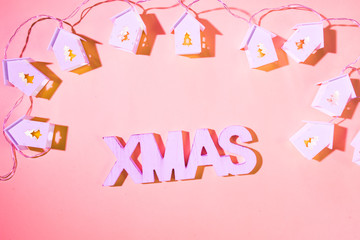 Christmas background, small home light  iluminated by electric lights lying on blue colored background with xmas decoration flat lay style