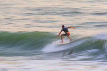 Panned shot of a surfer catching a wave, unrecognizable person