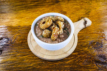 Mashed bean cracklings called Tutu de Feijao in Brazil. Brazilian beans with cabbage, large piece of pork rinds and beans. Rural food.