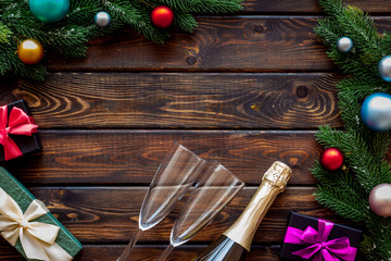 Presents for christmas in boxes, champagne and spruce frame on wooden background top veiw copyspace