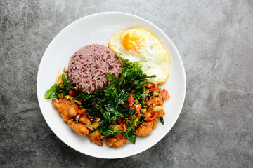 Crispy chicken cooked with green basil, served with steamed rice and fried egg, hot and spicy dish with basil leaves.