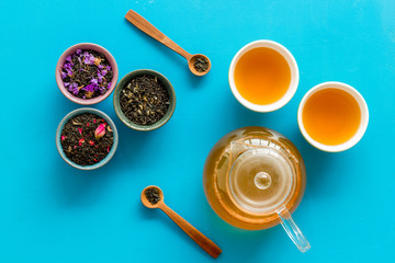 Tea ceremony with leaves and brew on blue background top view
