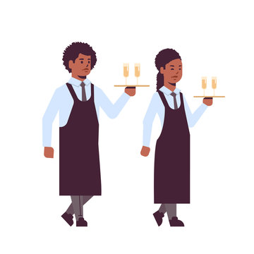 professional waiters holding serving trays with glasses of champagne african american man woman restaurant workers in uniform carrying alcohol drinks flat full length white background