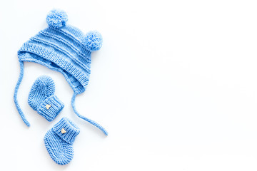 Booties and hat for newborn boy on white background top view mockup
