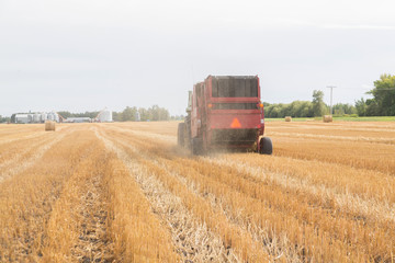 horizontal view of farmer bailing hay
