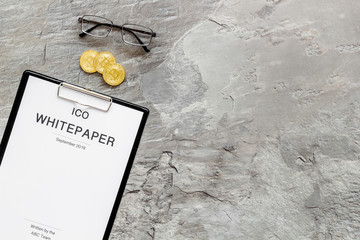 Initial coin offering ICO white paper on gray textured background top view mock-up