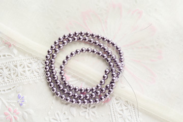 pearl necklace on white fabric background, Close up shot of glass pearls
