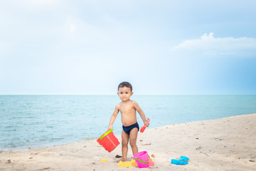 Cute Asian baby boy playing with beach toys