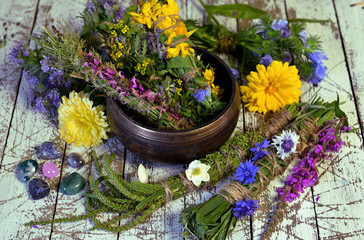 Bowl with herbs, plants and flowers on witch table.
