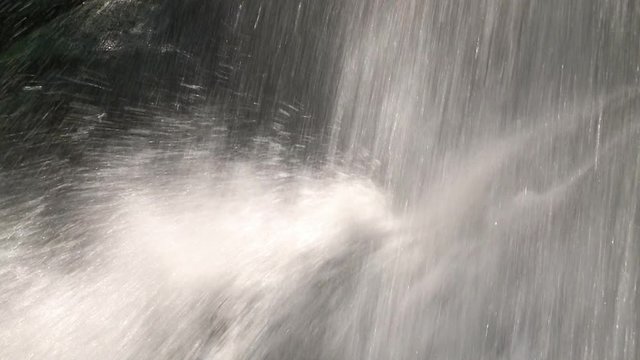 A steady, extreme close up shot of water splashing all over the place.