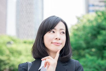 Young business woman thinking outdoors