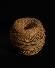 Vintage brown hemp rope roll isolated on a black background.