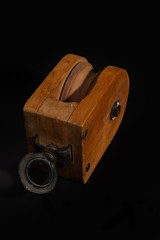 Vintage wooden pulley block isolated on a black background