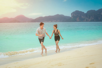 Fototapeta na wymiar Beach couple lover walking on the beach honeymoon vacation summer holidays romance.