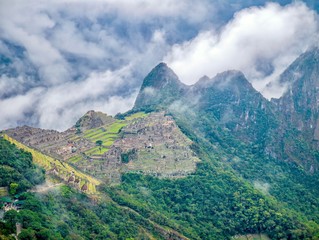 A spectacular high angle view of Machu Picchu, surrounded by mist and morning clouds, shot from the Sun Gate.
