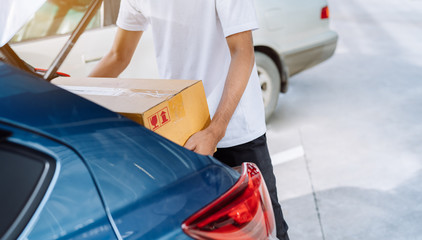 Delivery man carrying cardboard box for sending deliver to customer by transportation system hatchback car, Business of male transport sell part or product service parcel for convenience of customer